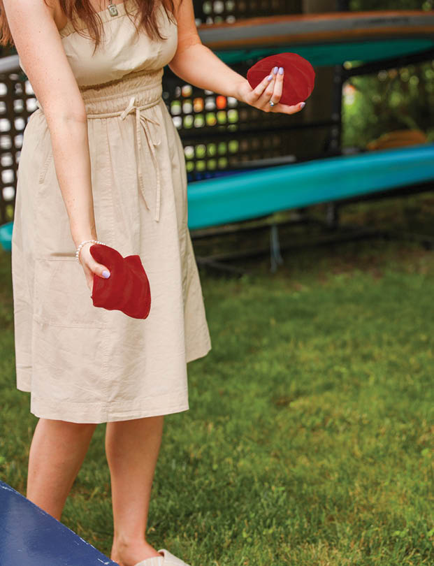 people playing cornhole, a popular American sport, representing camaraderie, outdoor leisure, competition, and the spirit of friendly gatherings